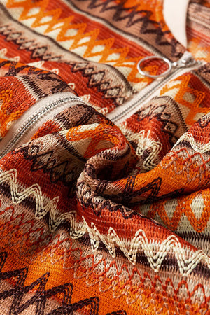 Close-up of a patterned fabric with orange, brown, and beige colors.
