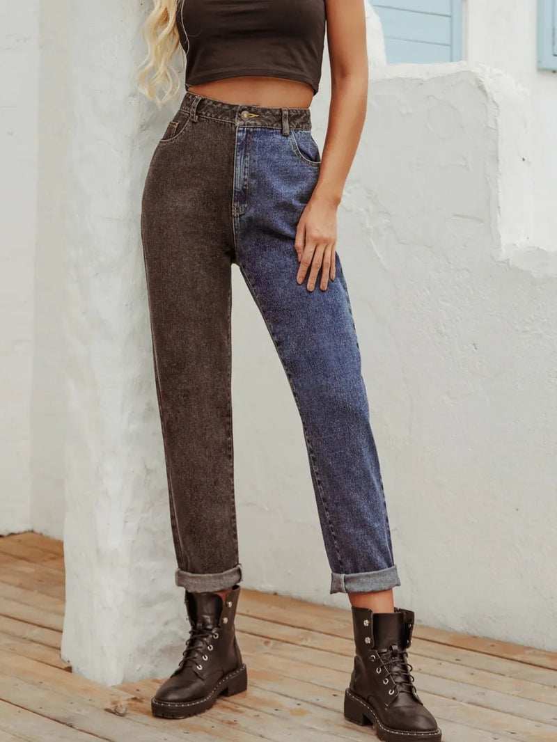 Person wearing a patchwork jeans outfit with brown and blue denim, standing against a light-colored wall.