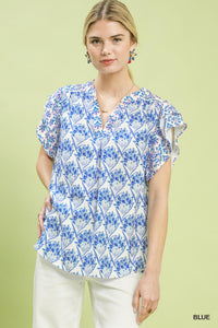 Woman wearing a blue floral blouse against a light green background