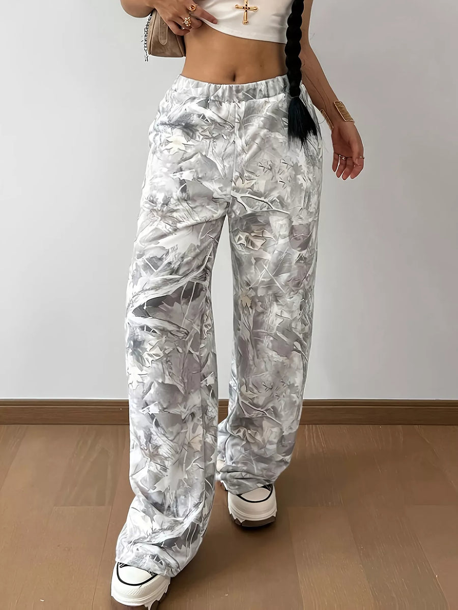 Person wearing white floral pants on a plain background