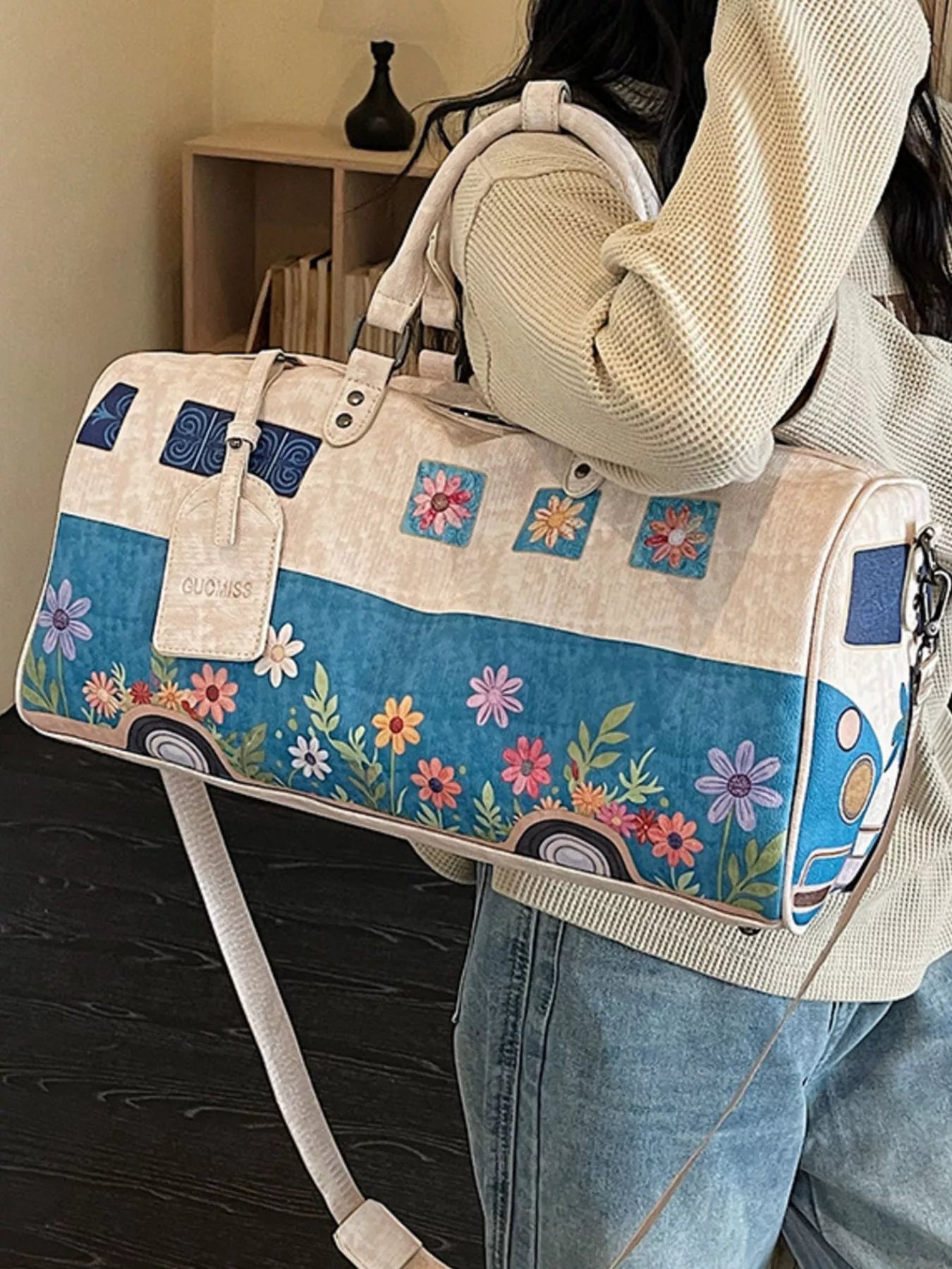 Person holding a floral and camper van design bag with a blurred background