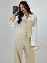 Woman taking a mirror selfie wearing a beige suit with a white shirt.