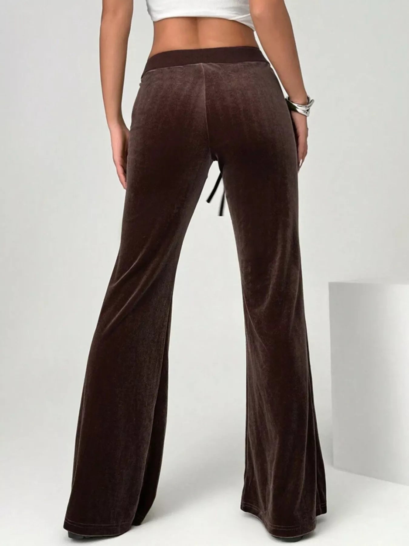 Brown velvet pants worn by a person on a white background