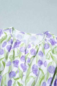 Close-up of a dress with purple floral pattern on a light gray background