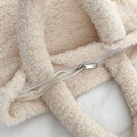 Close-up of a beige sherpa fabric with a zipper