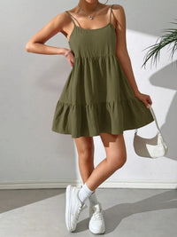 Person wearing a green dress with white sneakers against a plain background