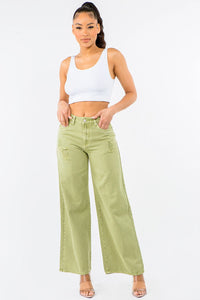 Woman wearing a white crop top and light green wide-leg jeans on a white background