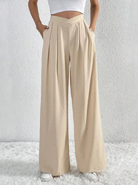 Beige wide-leg pants worn by a person on a white background