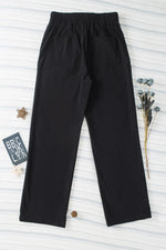 Black pants on a textured white background with decorative elements.