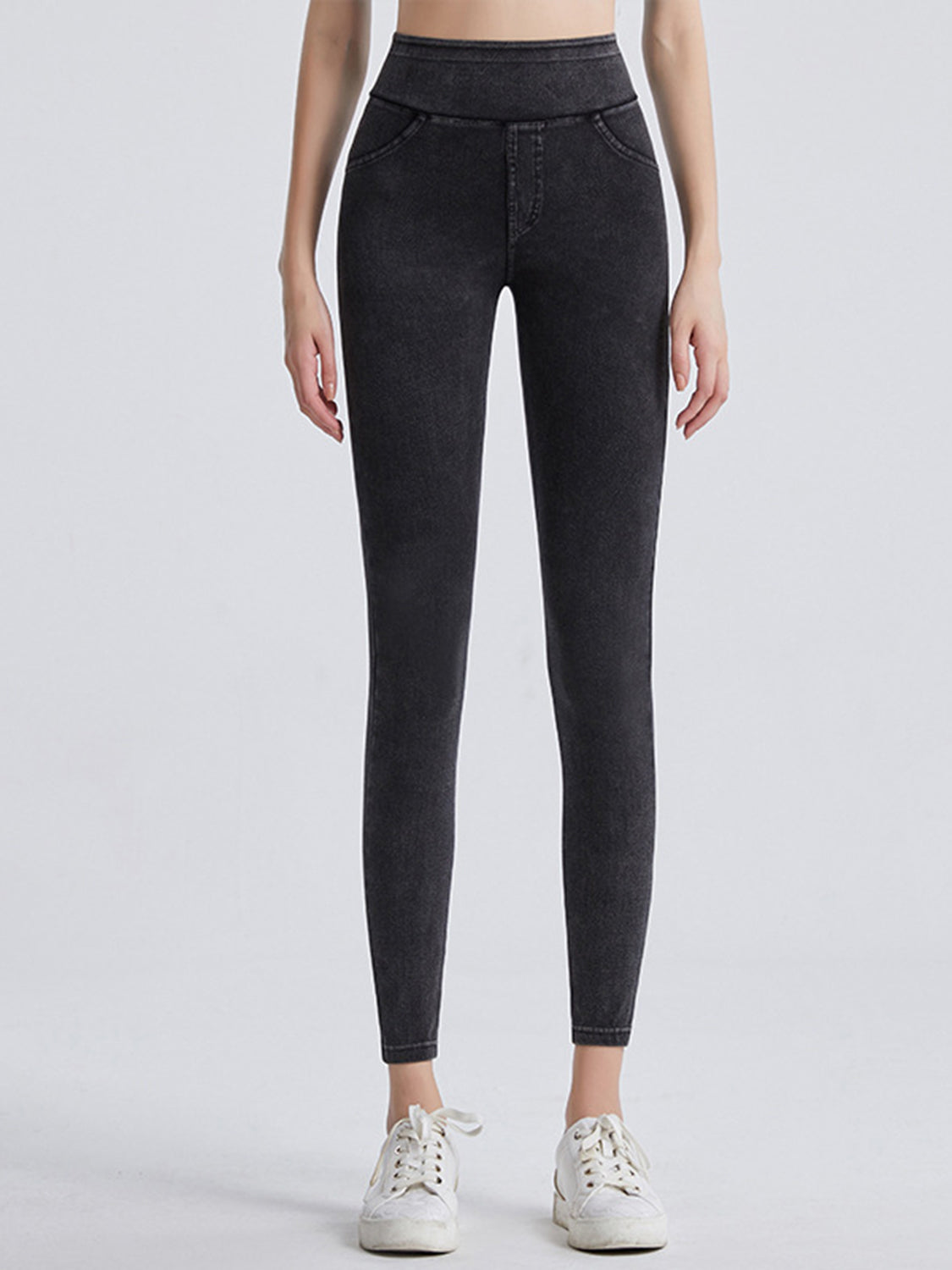 Person wearing black high-waisted jeans on a white background