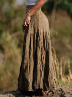 Person wearing a long, earthy-toned skirt standing in a natural setting.
