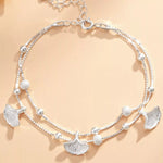 Silver necklace with leaf-shaped pendants on a beige background
