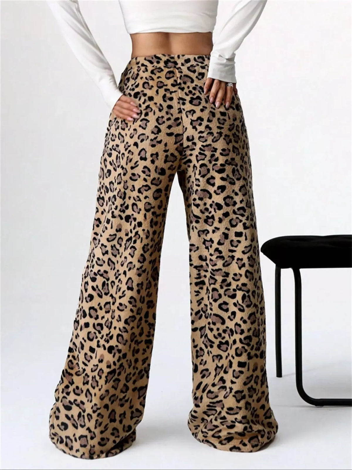 Leopard print pants worn by a person on a white background