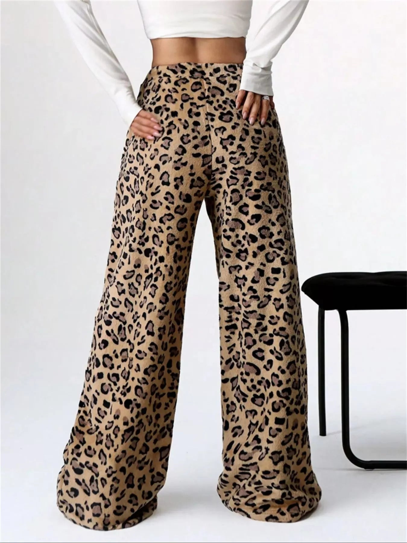 Leopard print pants worn by a person on a white background