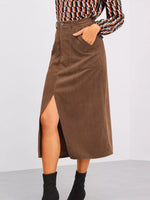 Brown corduroy skirt worn by a person on a plain background