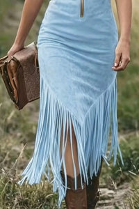 Light blue dress with fringe and brown boots in a natural setting