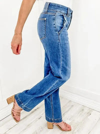 Person wearing blue jeans on a white wooden floor