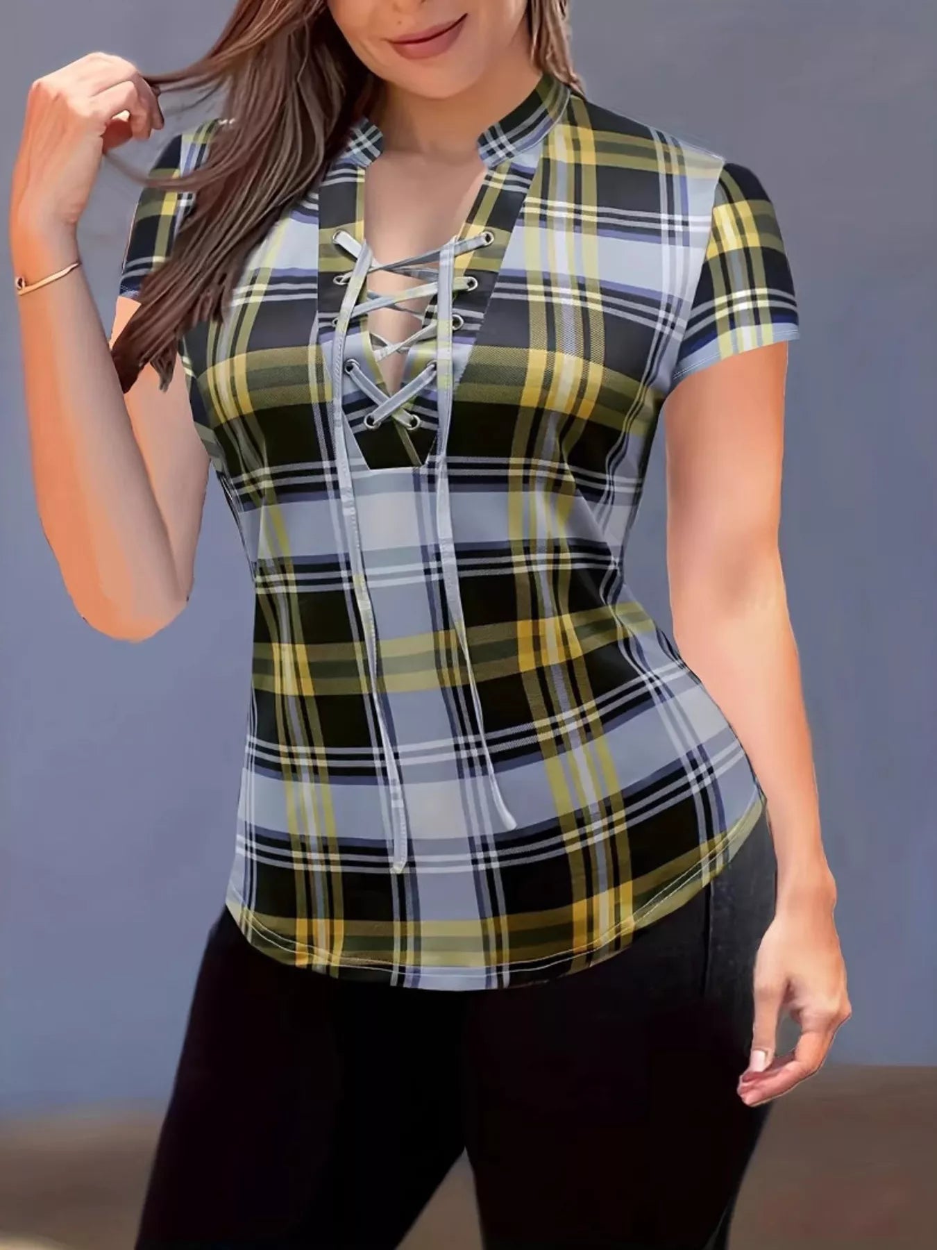 Woman wearing a plaid shirt with a lace-up front against a neutral background