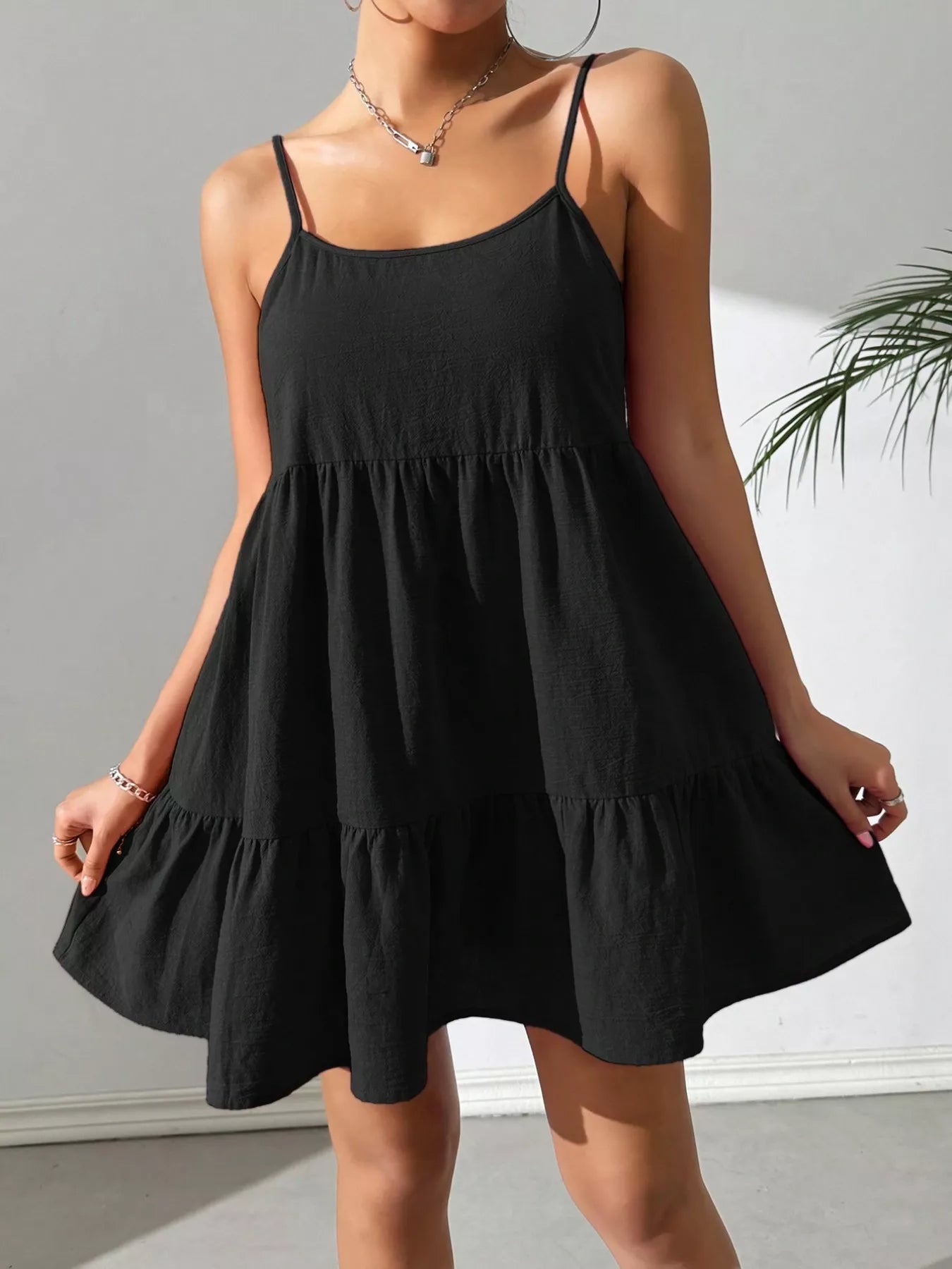 Black dress worn by a person against a neutral background