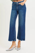 Blue jeans worn by a person on a light gray background