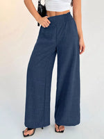 Person wearing blue wide-leg pants on a white background