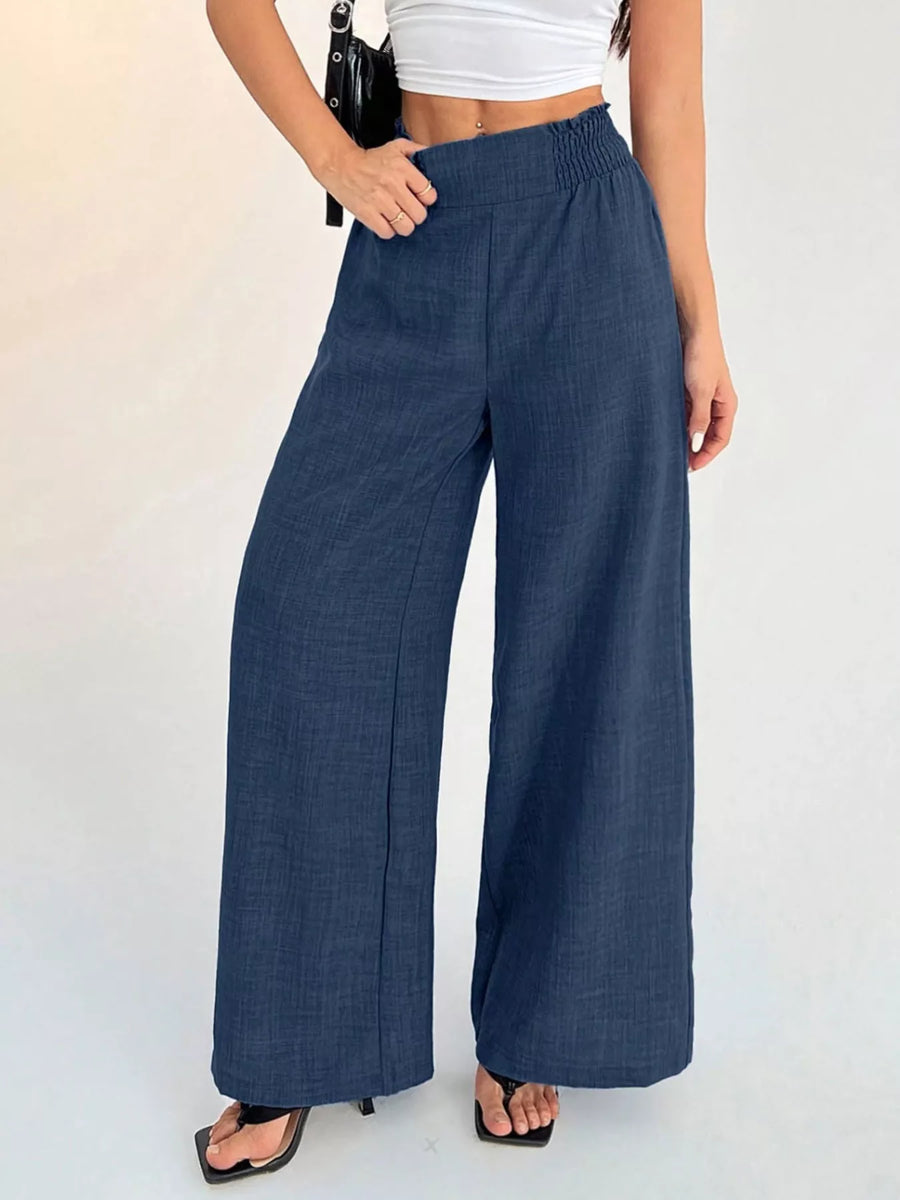 Person wearing blue wide-leg pants on a white background