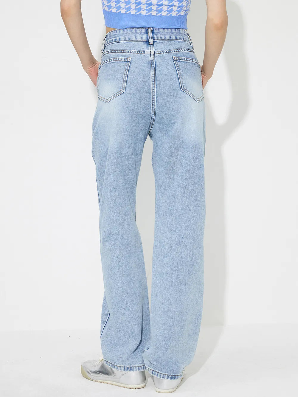 Light blue jeans worn by a person on a white background