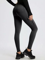 Person wearing black leggings with pockets on a white background