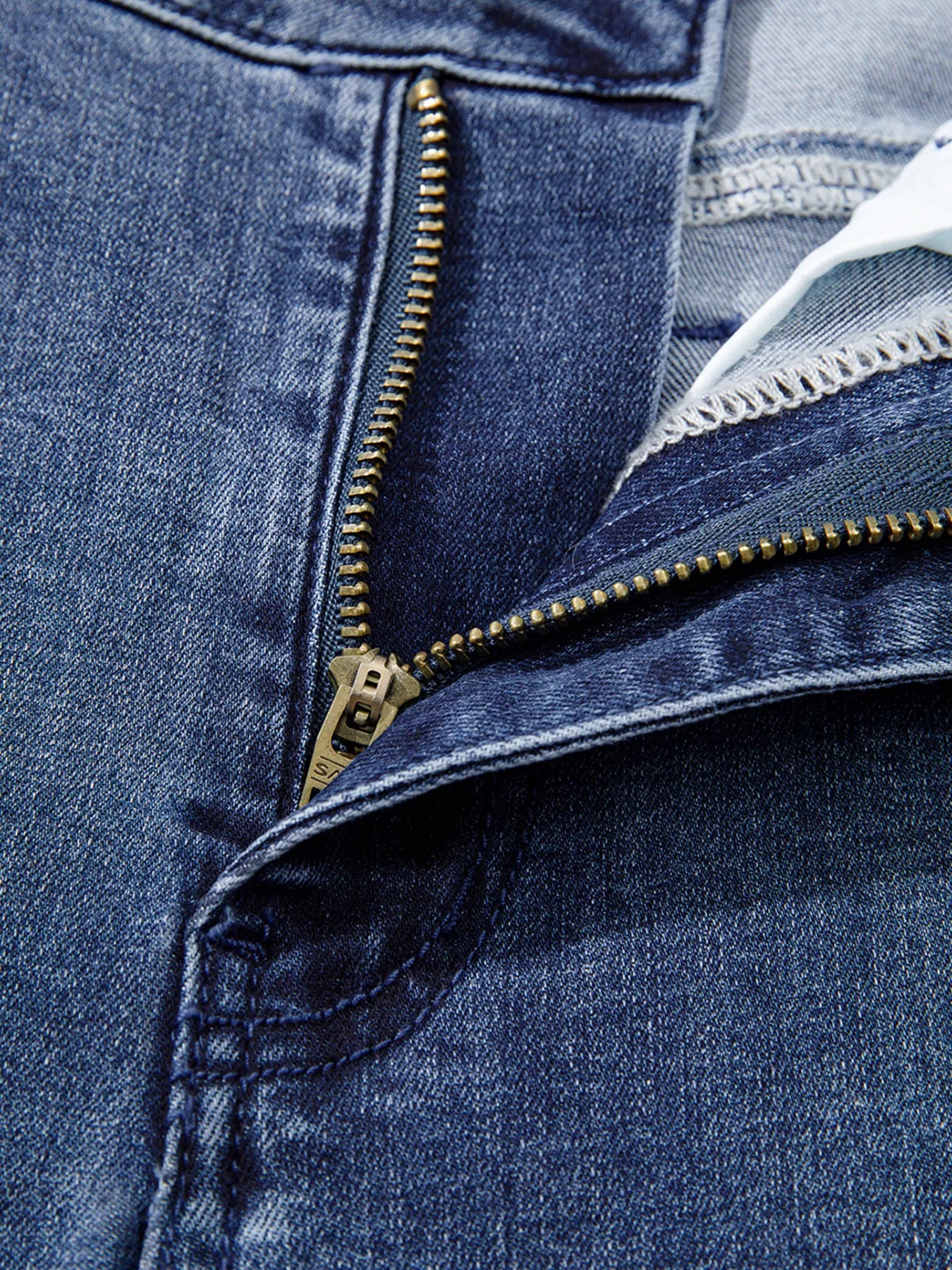 Close-up of a blue denim jacket with a zipper