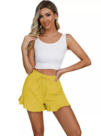 Woman wearing a white tank top and yellow shorts on a white background