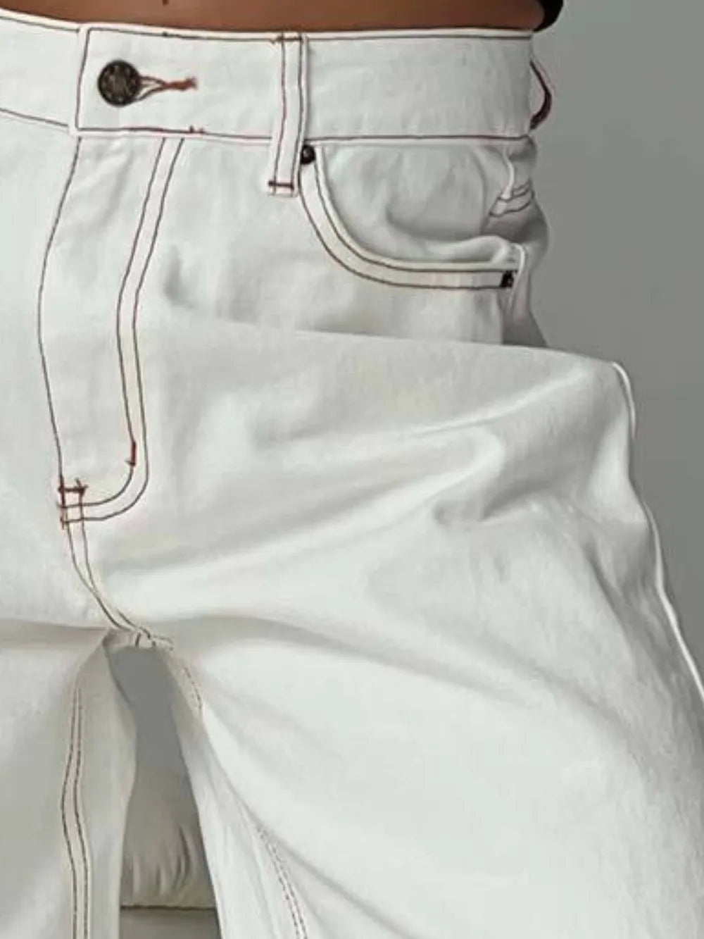 Close-up of white jeans with a plain background