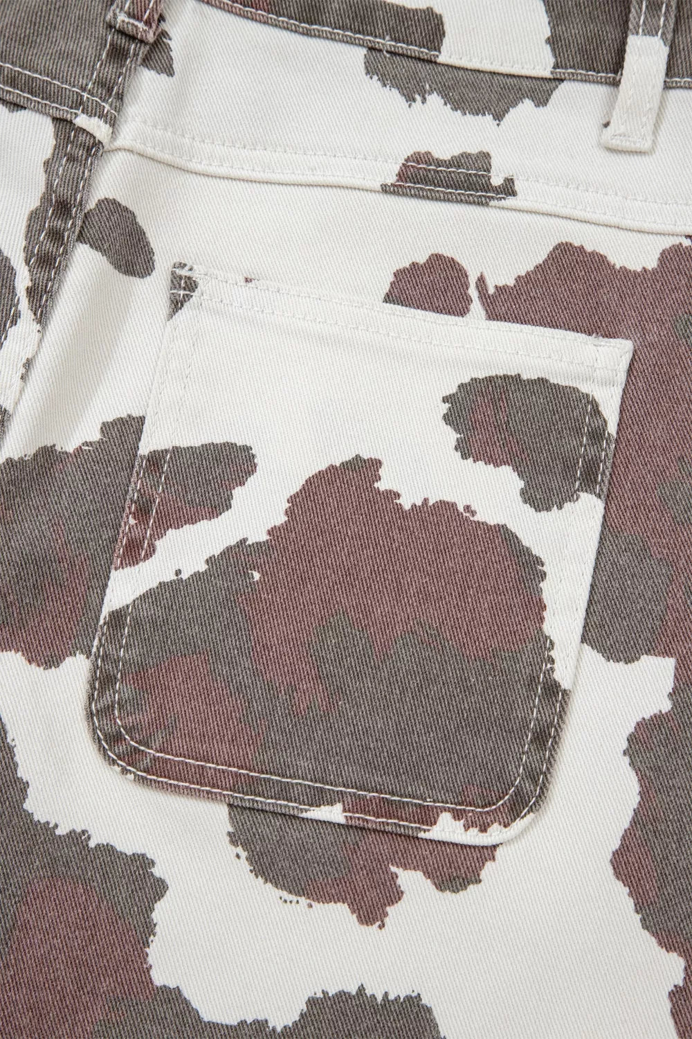 Close-up of a camouflage-patterned fabric with a pocket detail.