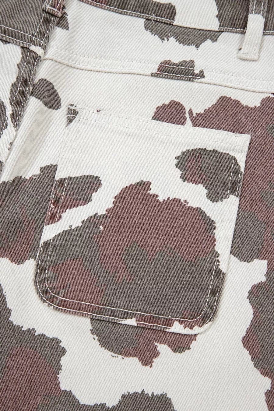 Close-up of a camouflage-patterned fabric with a pocket detail.