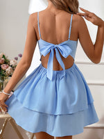 Light blue dress with open back and bow detail worn by a person, with flowers in the background.