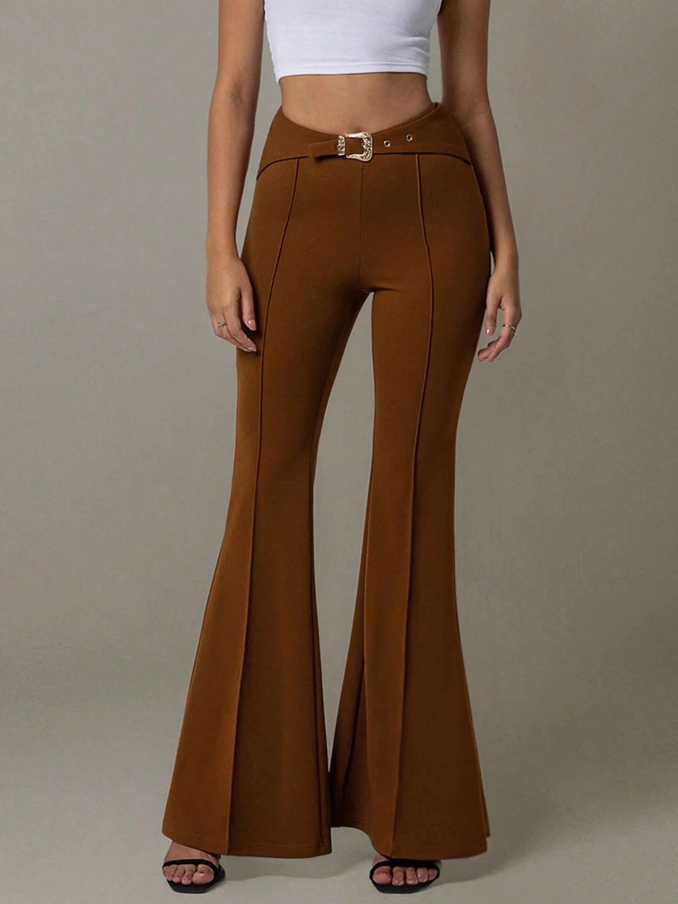 Brown flared pants worn by a person on a plain background