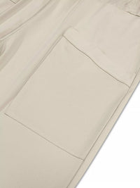 Close-up of beige pants with a pocket on a white background