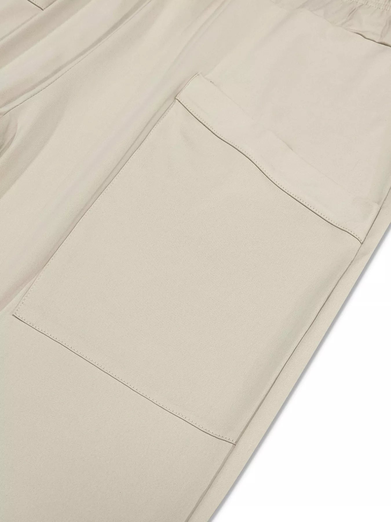 Close-up of beige pants with a pocket on a white background