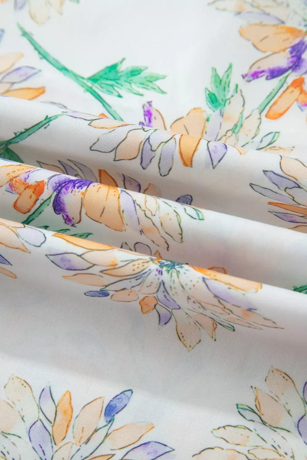 Floral patterned fabric with orange, purple, and green colors on a white background