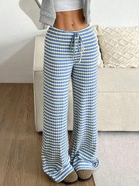 Person wearing blue and white checkered pants in a living room setting