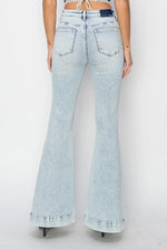 Light blue flared jeans worn by a person on a white background