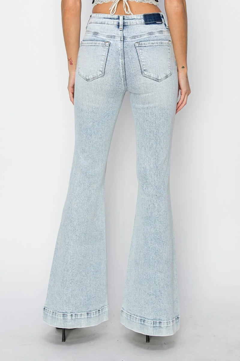 Light blue flared jeans worn by a person on a white background