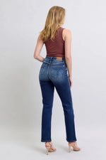 Woman wearing blue jeans and a brown top on a white background