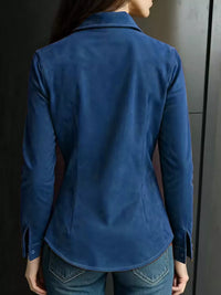 Person wearing a blue jacket in front of a dark background