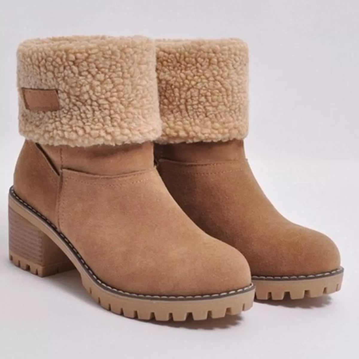 Tan ankle boots with shearling collar on a light gray background
