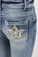 Close-up of blue jeans with a star patch on the pocket.