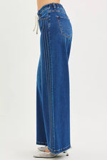 Blue jeans worn by a person on a white background