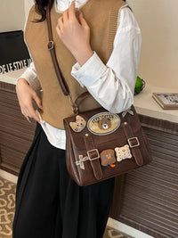 Person holding a brown bag with bear-themed decorations in an indoor setting