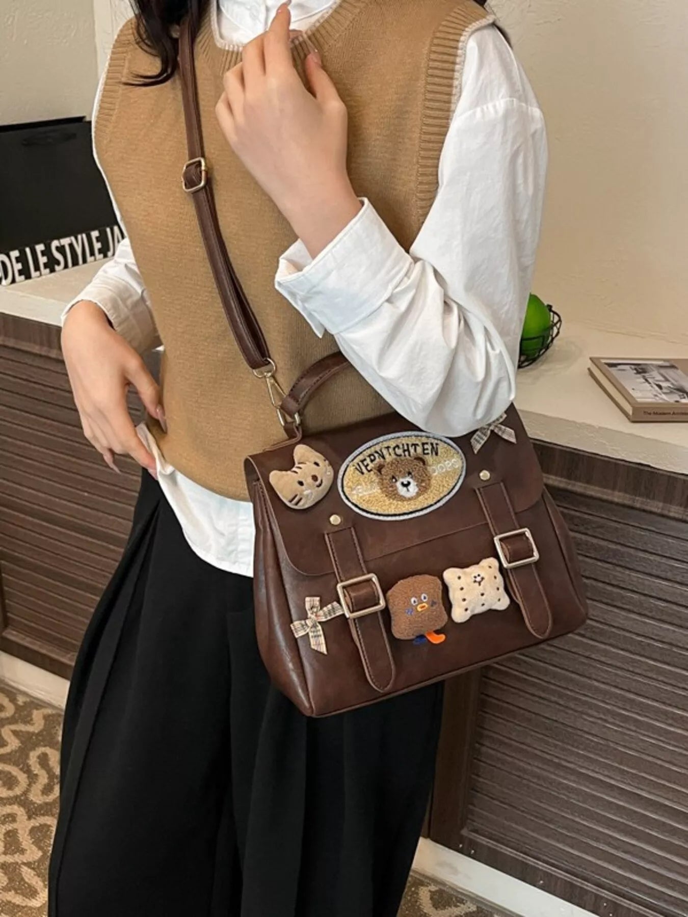 Person holding a brown bag with bear-themed decorations in an indoor setting
