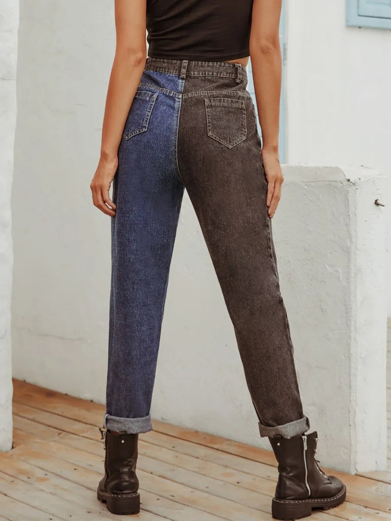 Person wearing two-tone jeans with a white wall background