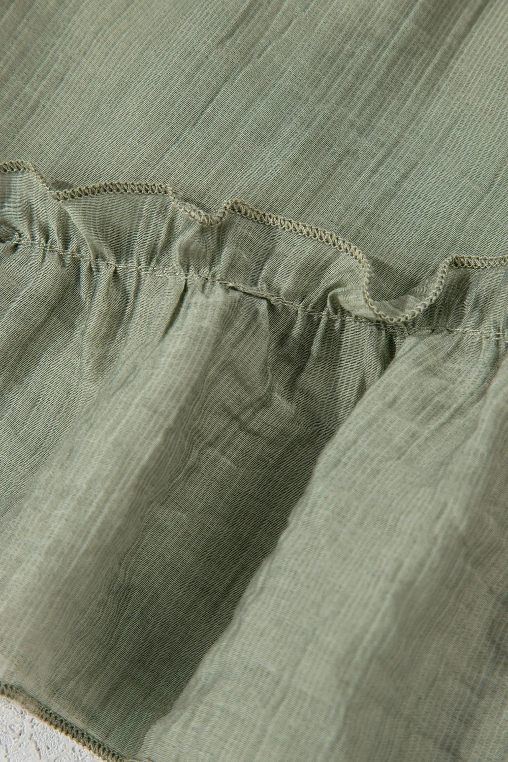 Close-up of green fabric with ruffled edge